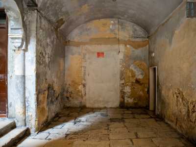 Non ci resta che entrare. L�accoglienza non � delle migliori: ci ritroviamo infatti in un cupo e malconcio androne a volta con muri scrostati e differenti strati di intonaci grigi, ocra e azzurri